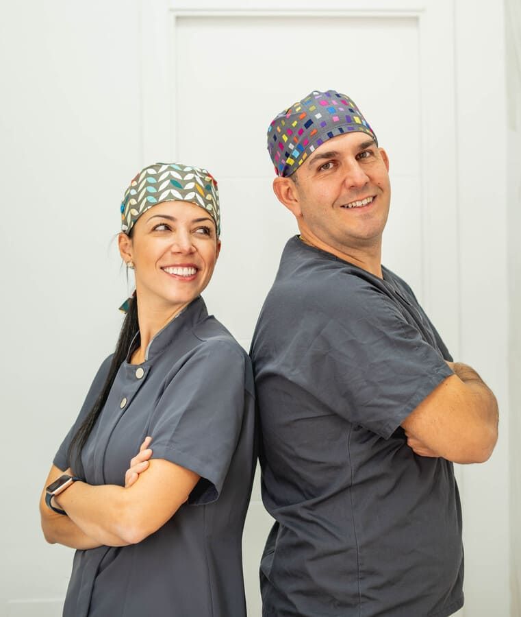 Un hombre y una mujer de pie, espalda con espalda y con los brazos cruzados.