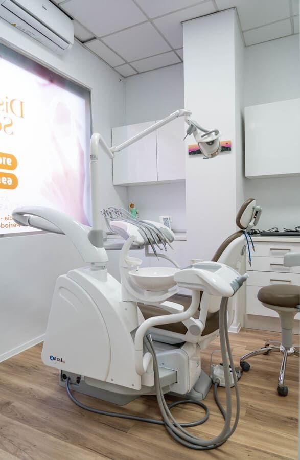 Un consultorio dental con un sillón dental y una ventana.