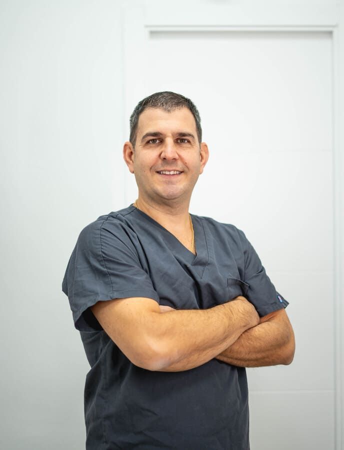 Un hombre con un matorral posa para una fotografía con los brazos cruzados.