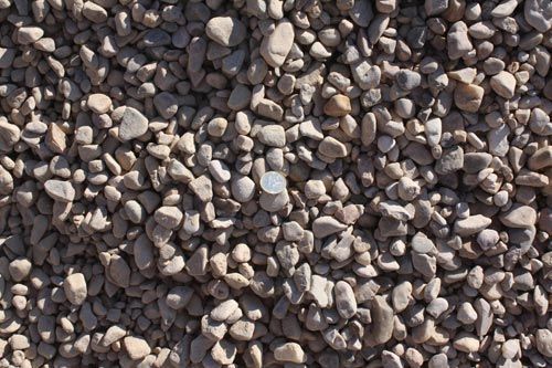 Un montón de grava con una moneda en el medio.