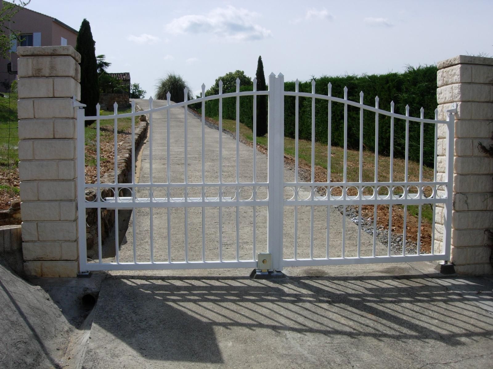 Portail blanc ouvrant sur une grande allée