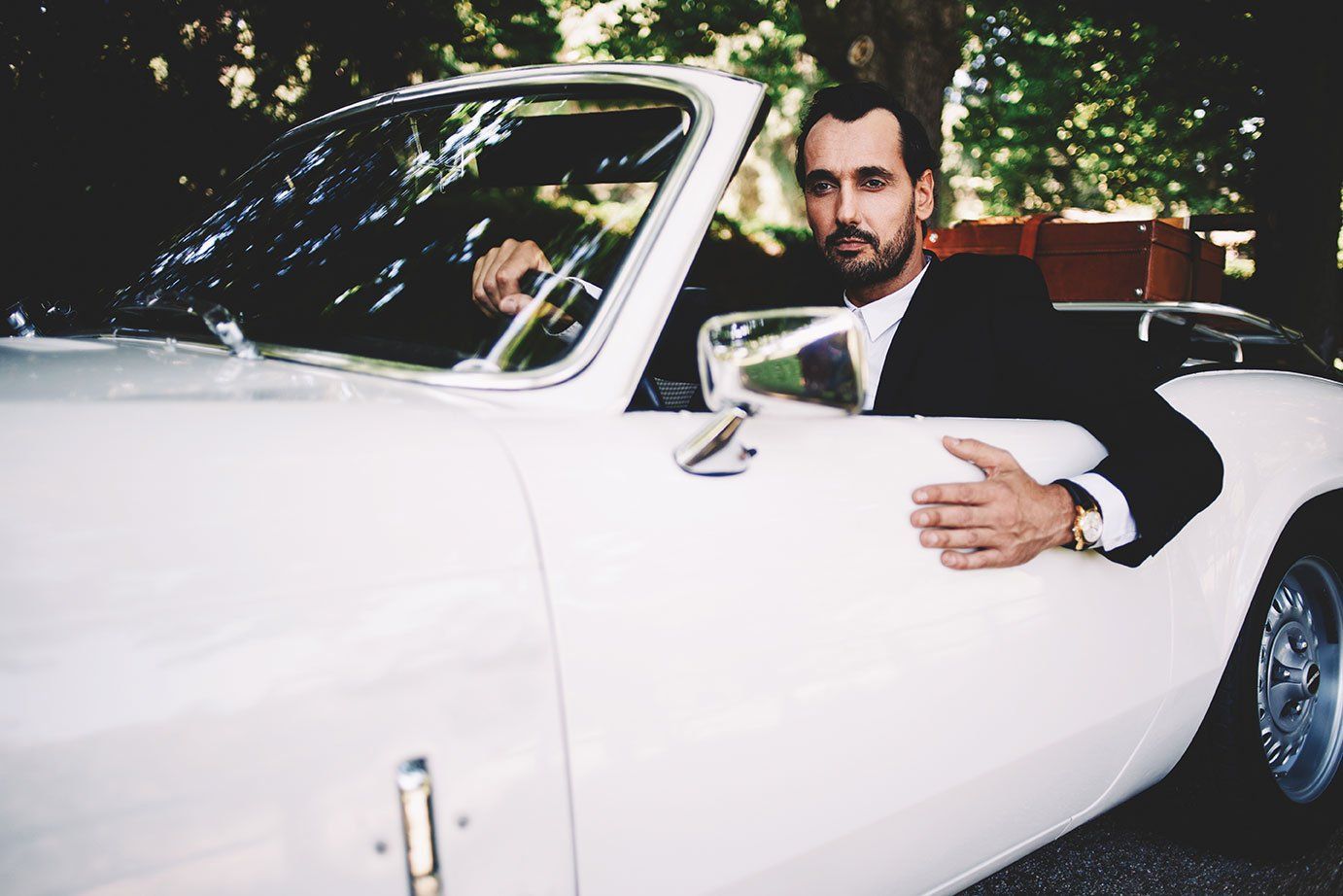 Homme dans une voiture de collection blanche