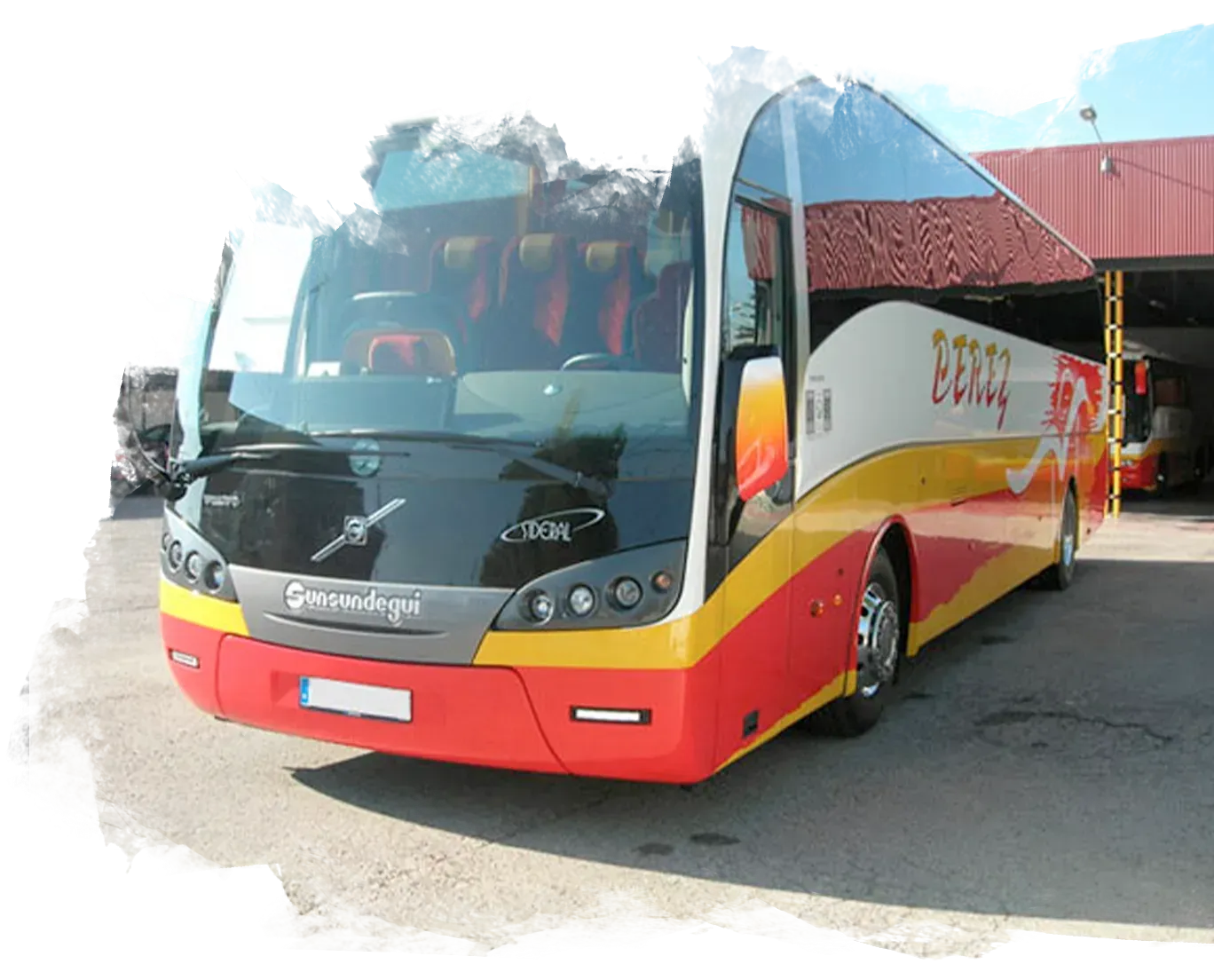Un autobús rojo y amarillo está estacionado en un estacionamiento.
