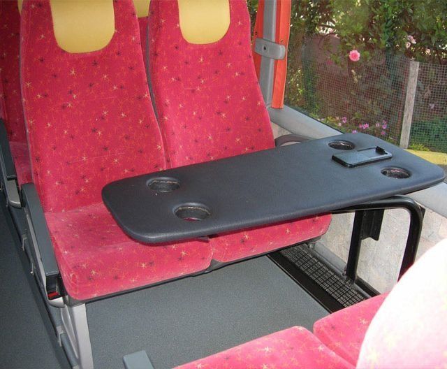 Un asiento rojo con una mesa negra adjunta.