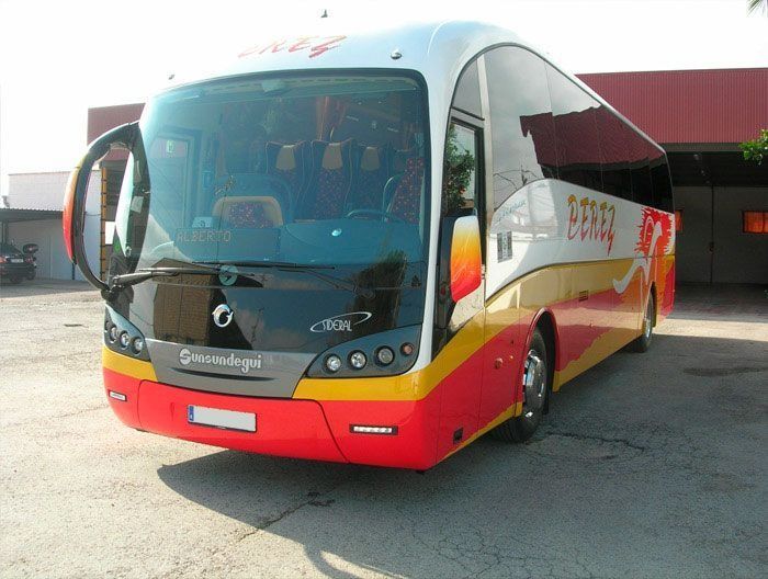 Un autobús rojo y amarillo está estacionado en un estacionamiento.