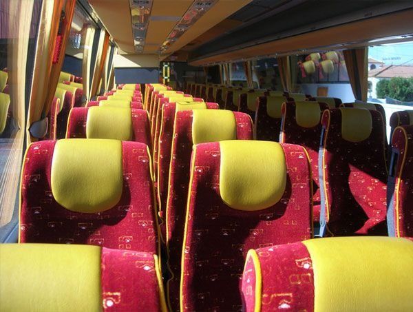 Filas de asientos rojos y amarillos en un autobús