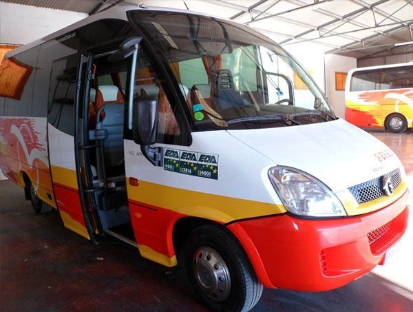 Un autobús rojo, blanco y amarillo con el número 1 en el costado