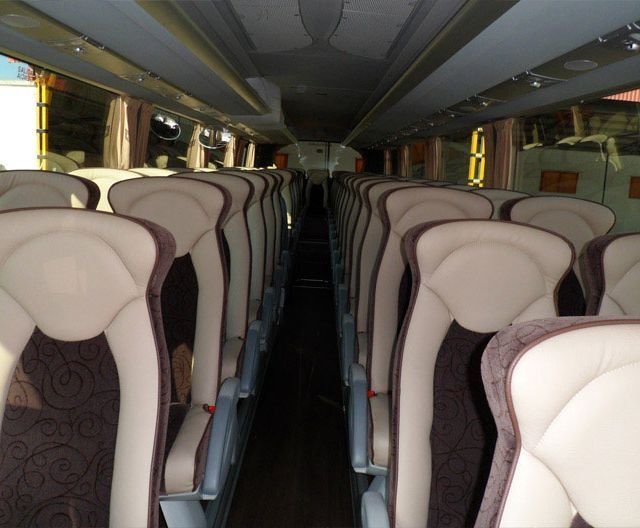 El interior de un autobús con muchos asientos.