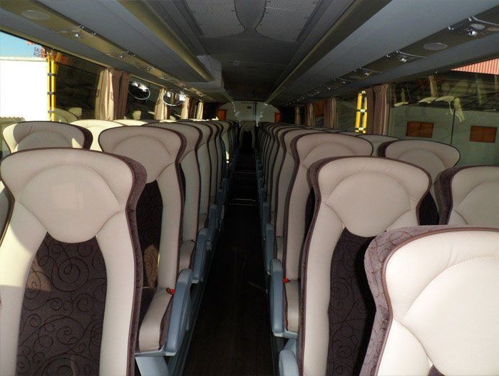 El interior de un autobús con muchos asientos.
