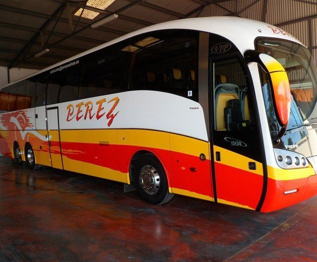 Un autobús rojo y amarillo con la palabra Pérez en el costado.