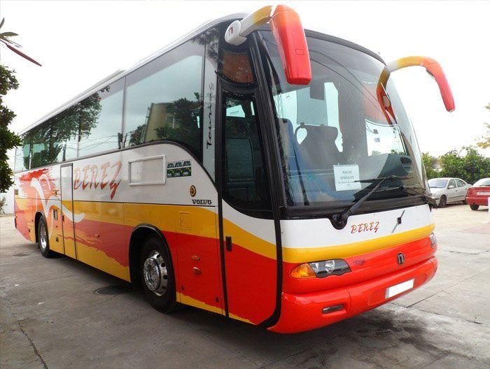 Un autobús rojo y amarillo está estacionado en un estacionamiento.
