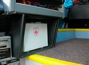 Un botiquín de primeros auxilios está debajo de un asiento en un autobús.