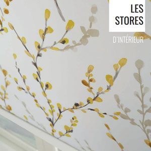 Mur blanc avec papier peint à feuilles jaunes à côté d'un escalier, portant l'inscription « Les Stores d'Intérieur »