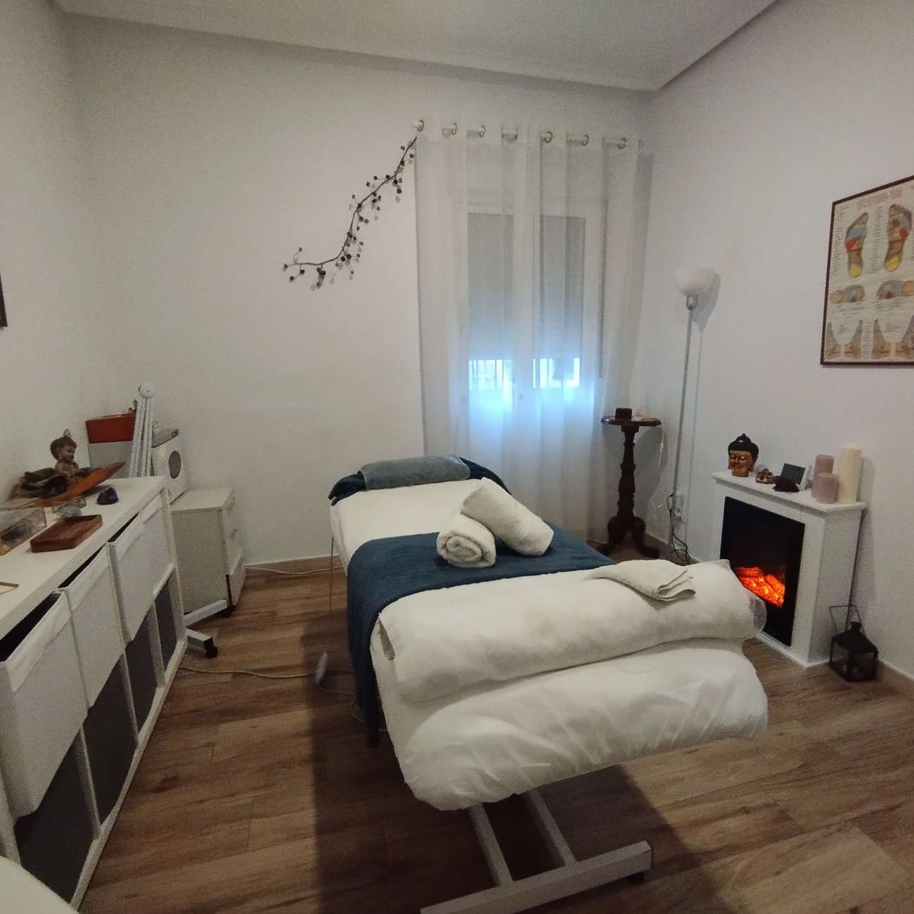 Una habitación con mesa de masajes y chimenea.