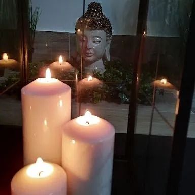 Estatua de buda alumbrada con velas
