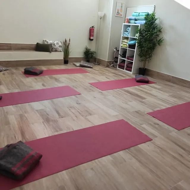 Una habitación con muchas colchonetas de yoga rosas en el suelo.