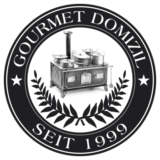 Logo mit Herd, Töpfen und „GOURMET DOMIZIL SEIT 1999“ im Kreis, mit Lorbeerzweigen und Sternen.