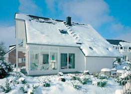 Weißes Haus mit Schnee auf dem Dach