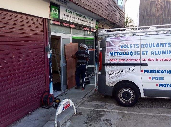 Un professionnel installe un rideau métallique