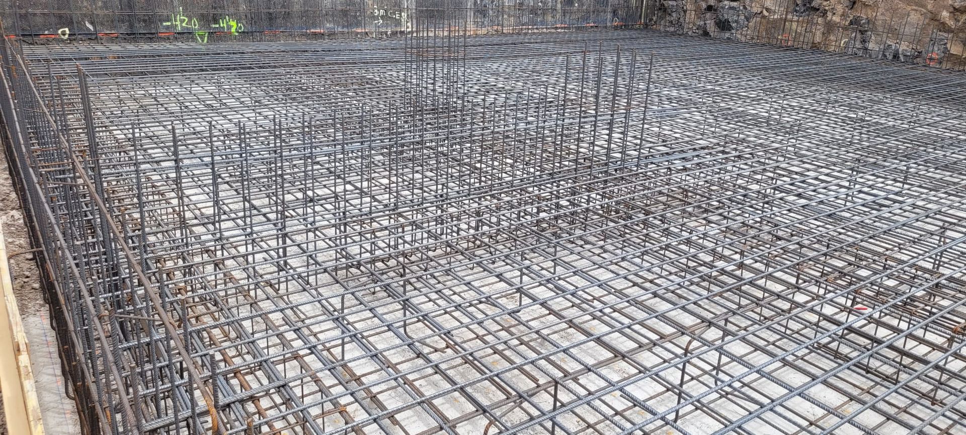 Un primer plano de un piso de concreto con una valla al fondo.