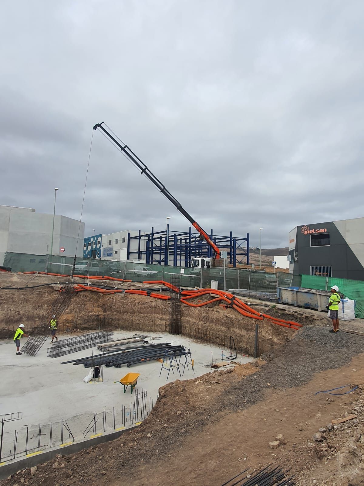 Una gran grúa está levantando una gran cantidad de hormigón en un sitio de construcción.