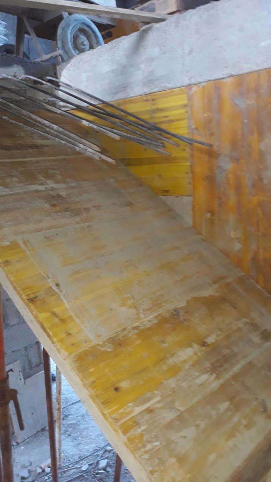 Una mesa de madera con un montón de varillas de metal sobre ella.