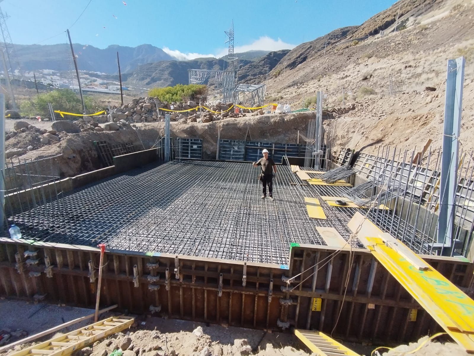 Un hombre está parado en medio de un sitio de construcción.