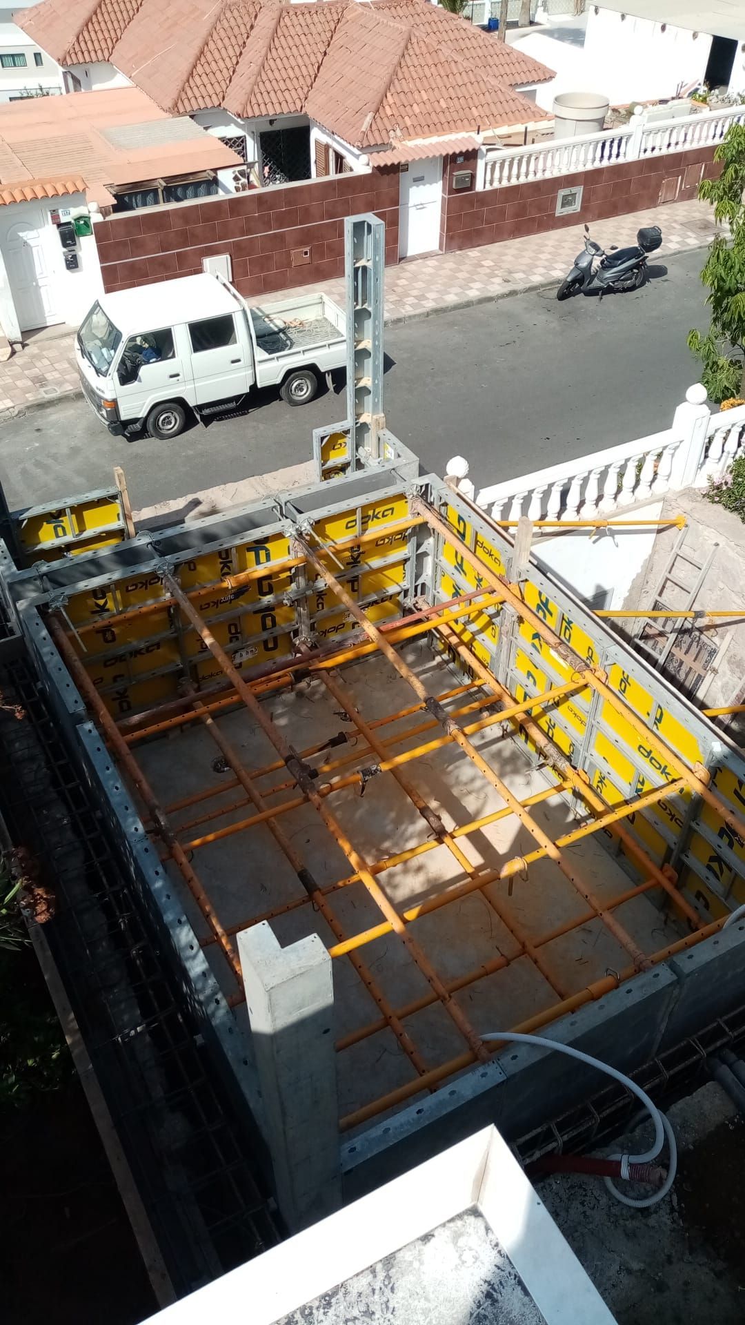 Una vista aérea de un sitio de construcción con un camión estacionado al fondo.