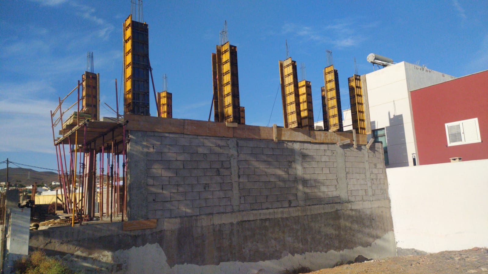 Se está construyendo un muro de ladrillos al lado de un edificio en construcción.