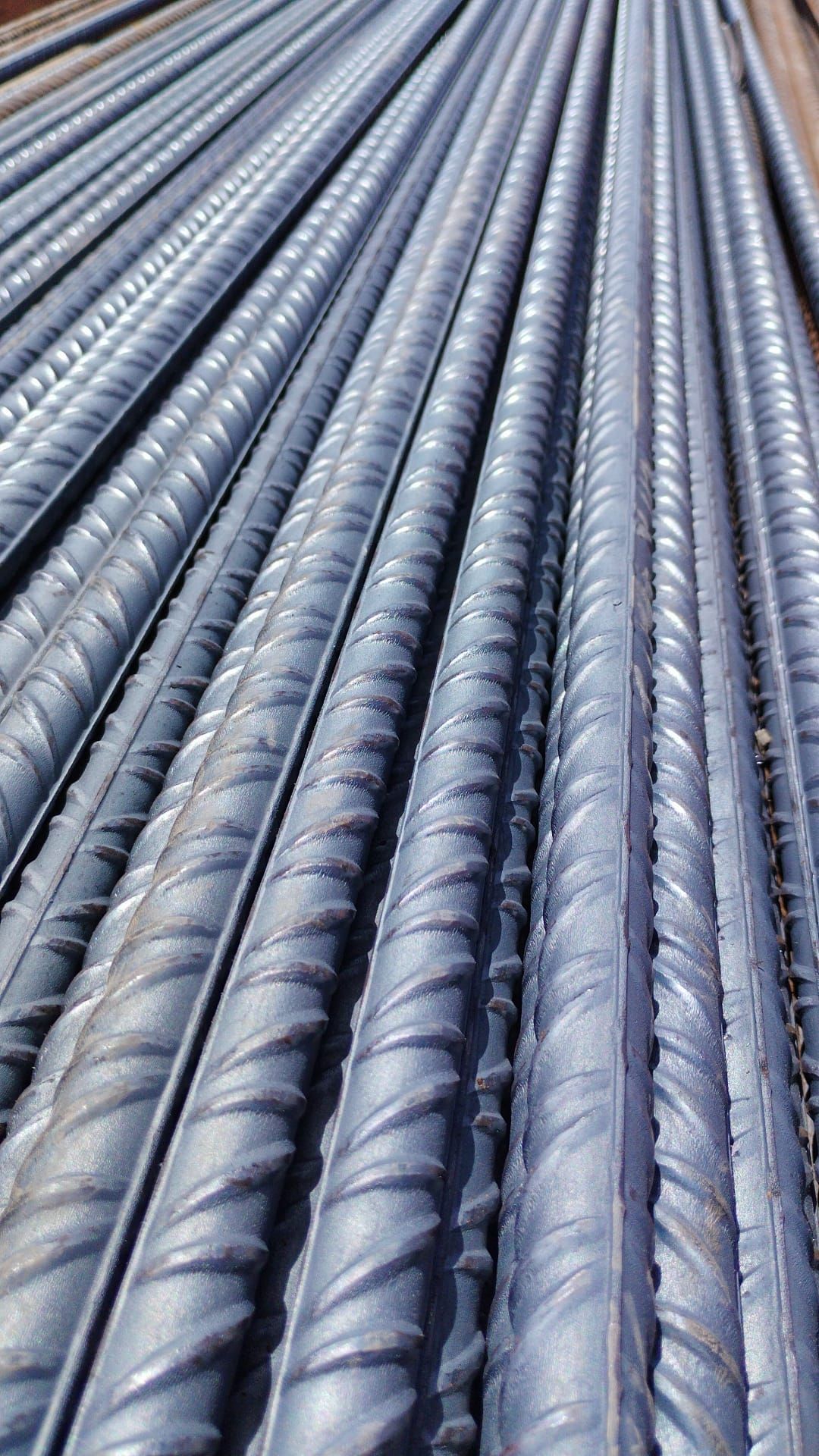 Un primer plano de un montón de barras de acero apiladas una encima de otra.