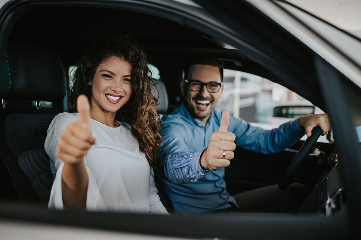 Couple heureux qui achète une voiture dans un showroom