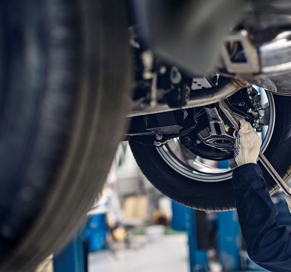 Homme qui examine les suspensions d'une voiture