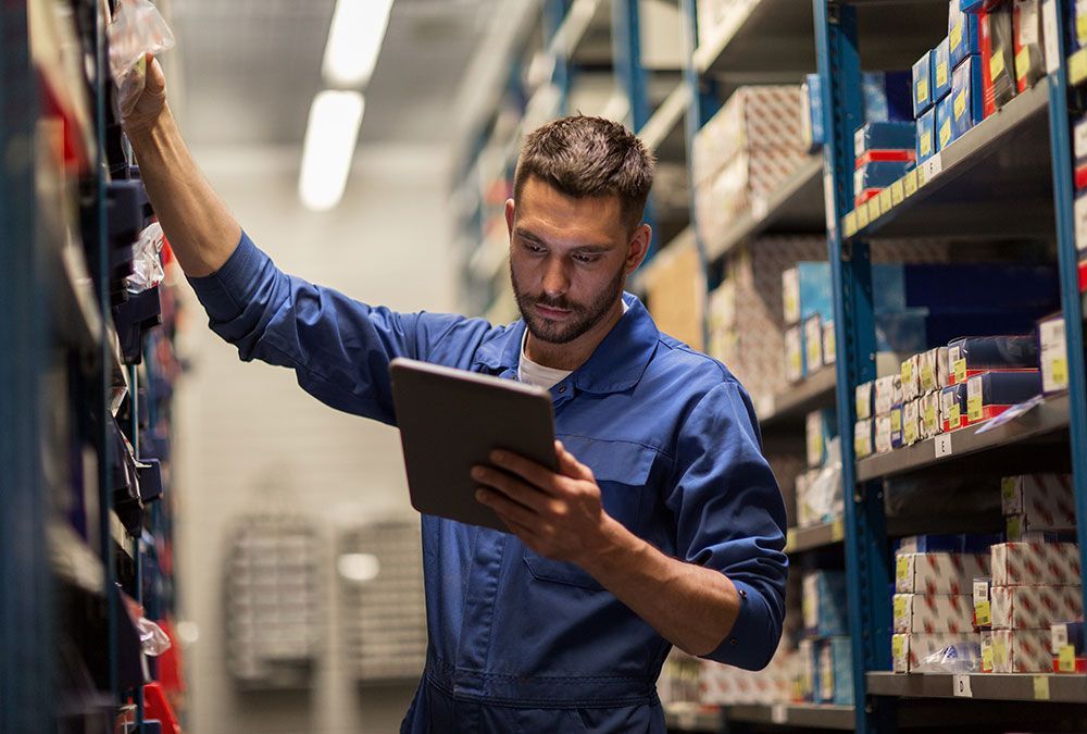 Homme qui recherche des pièces de voiture avec une tablette dans ses mains