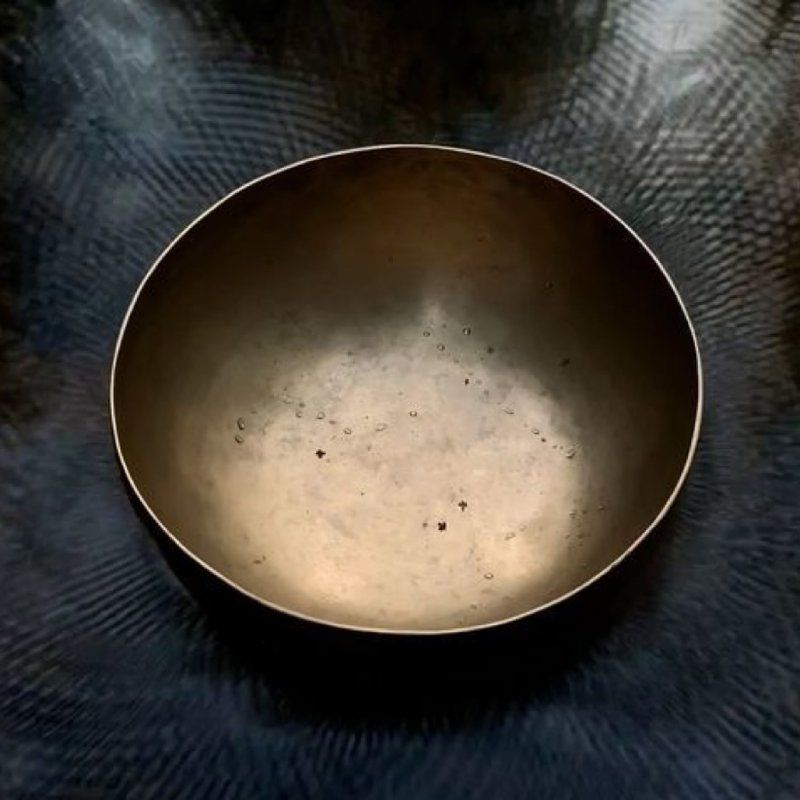 Un bol vide est posé sur une surface sombre