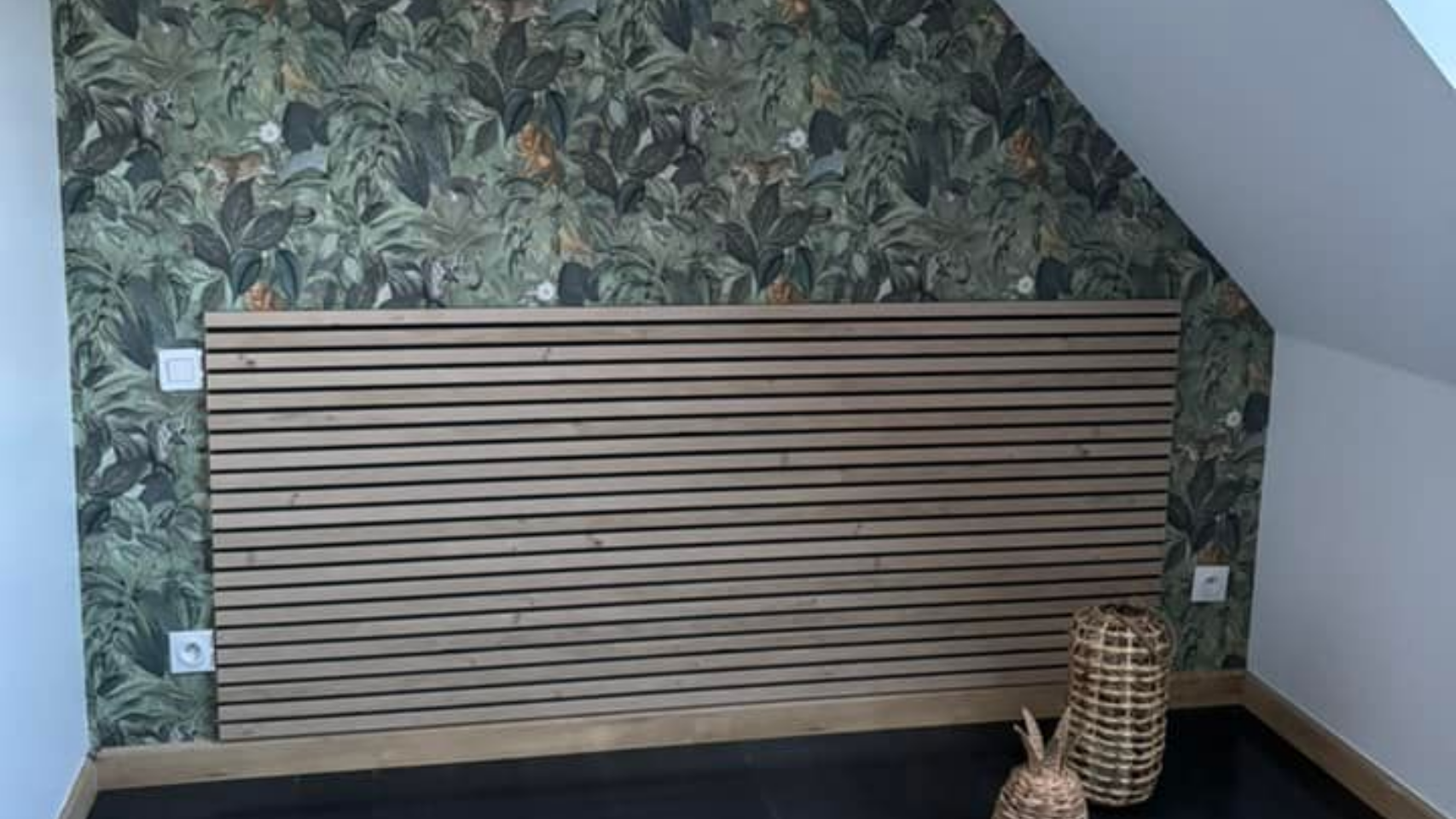 Tête de lit en latte de bois sur un mur avec décor en papiers peints