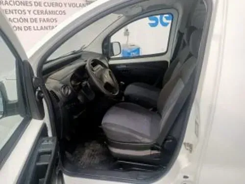 El interior de una camioneta blanca con la puerta abierta.