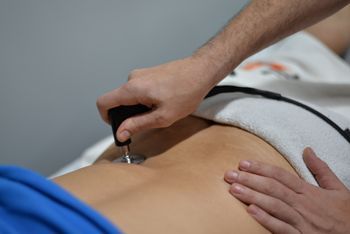 Un hombre le está dando un masaje a una mujer en el estómago.