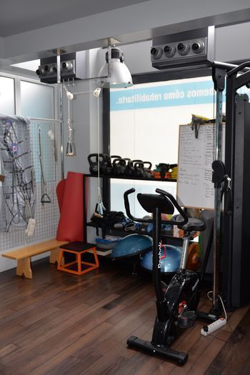 Una habitación con una bicicleta y un banco dentro.