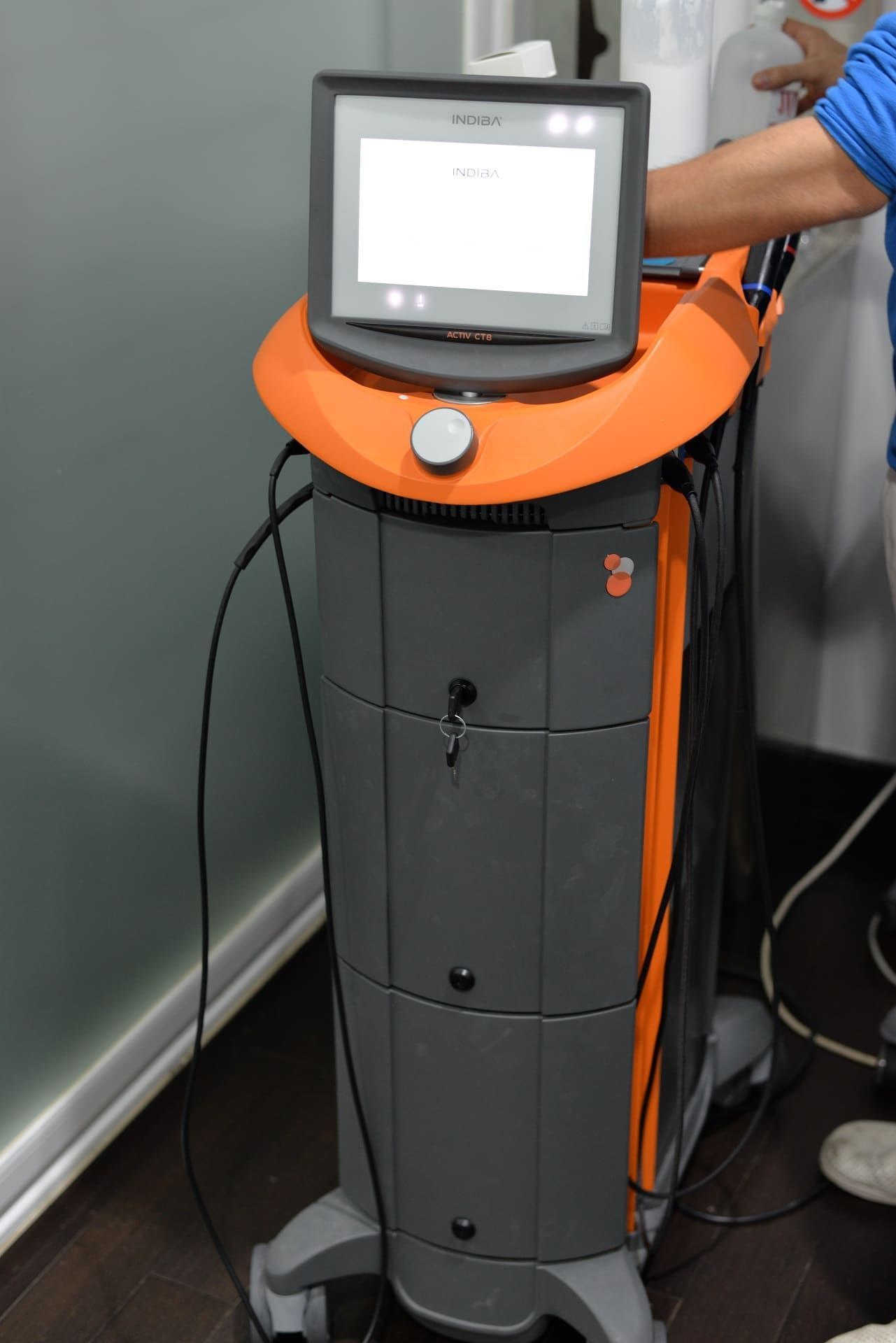 Una máquina gris y naranja con un monitor encima.