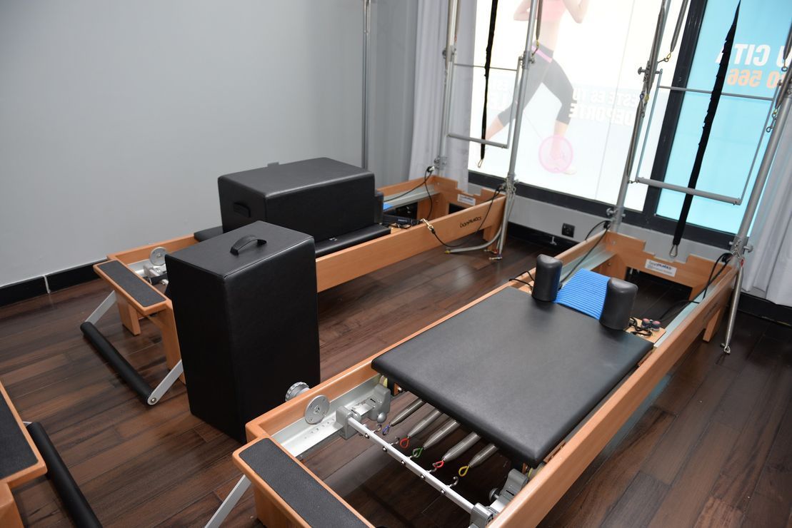 Una máquina de pilates está en una habitación al lado de una ventana.