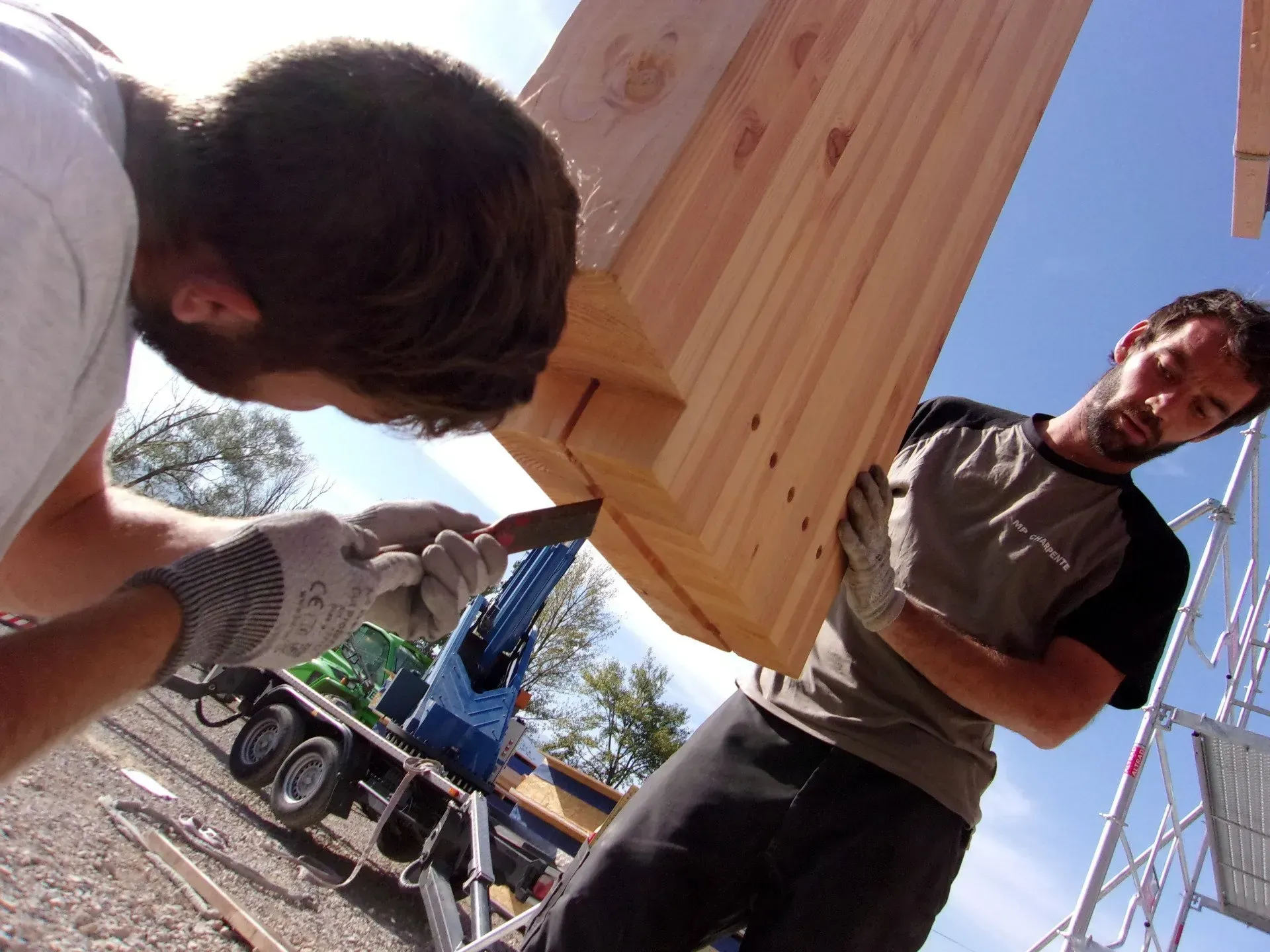 Ouvriers en train de poser en poutre en bois