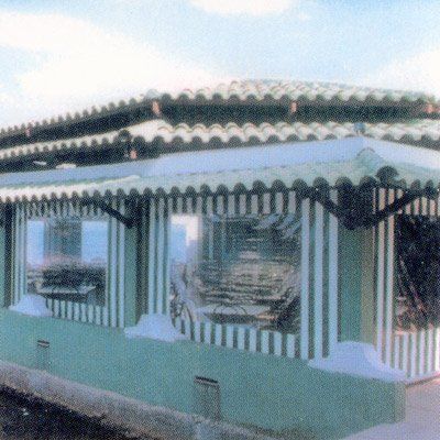 Un edificio de rayas verdes y blancas con techo.
