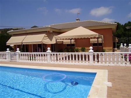 Una casa grande con piscina delante de ella.