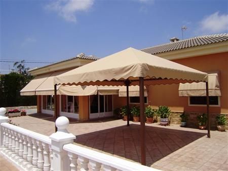 Una casa con un patio y un toldo delante