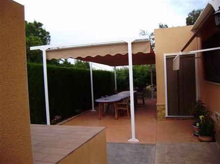 Un patio con una mesa y sillas bajo un dosel.