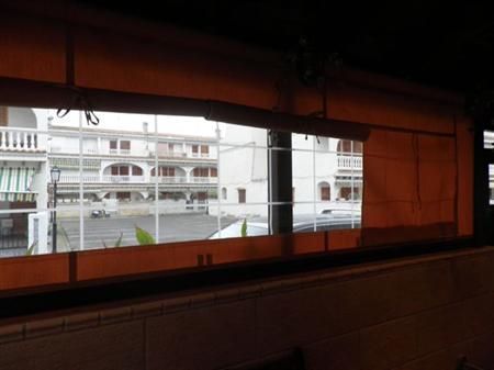 Una gran ventana con vista a un edificio detrás de ella.
