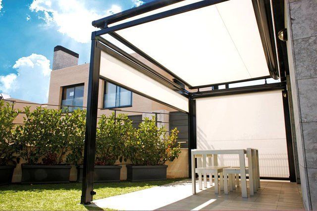 Un patio con una mesa y sillas bajo un dosel.