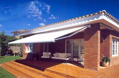 Una casa de ladrillo con un toldo blanco sobre el porche