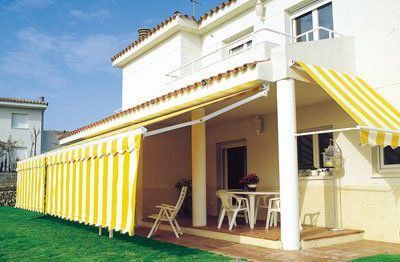 Una casa blanca con un toldo amarillo en el porche