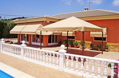 Una casa grande con piscina delante de ella.